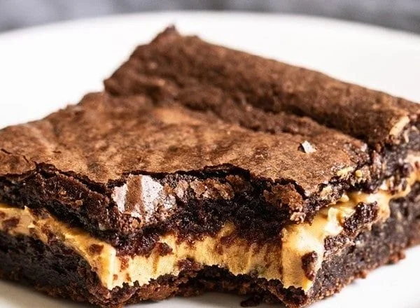 Peanut butter filled brownies topped with chocolate and peanut butter drizzle