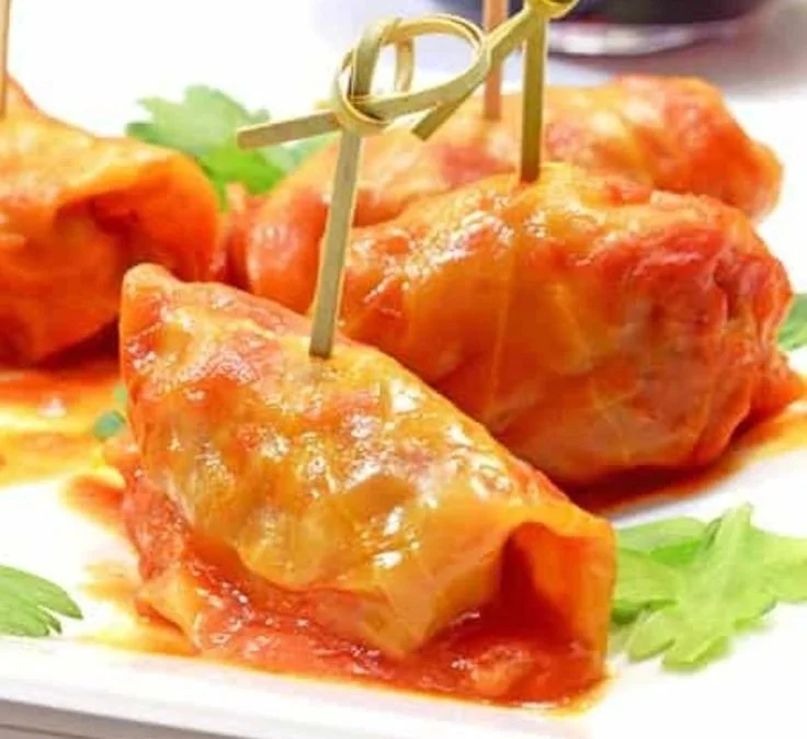 Polish stuffed cabbage rolls filled with meat and rice, topped with tomato sauce