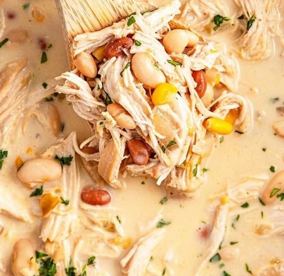 Bowl of creamy Slow Cooker White Chicken Chili garnished with cilantro and lime.
