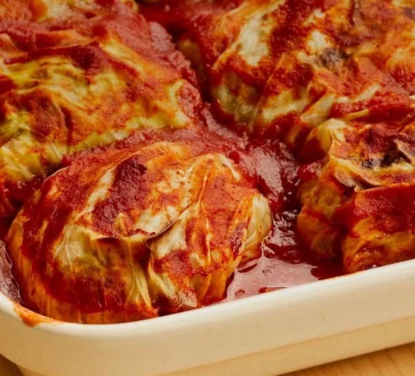 Traditional stuffed cabbage rolls served on a plate with fresh herbs