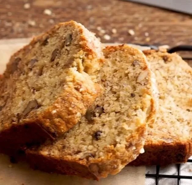A loaf of ultimate moist banana bread fresh from the oven, sliced for serving.